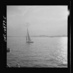 Black and white photo of a sailboat on water